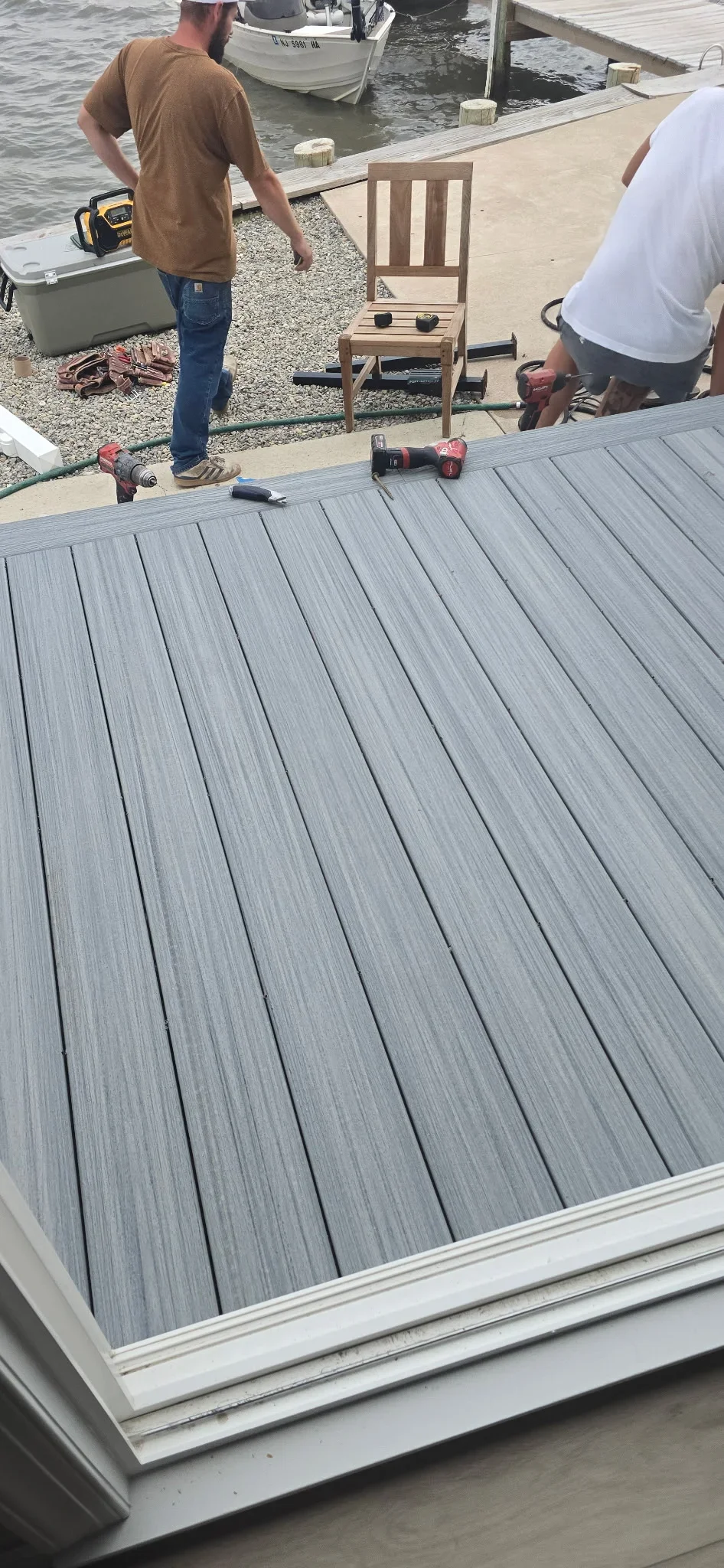Gray composite deck boards with white trim installed on waterfront property