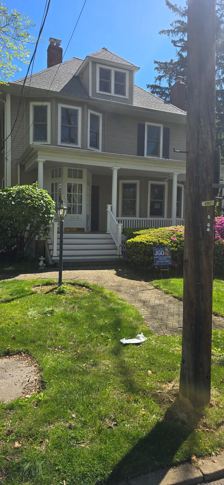 Gray vinyl siding, white trim windows, front porch with columns, architectural shingle roof