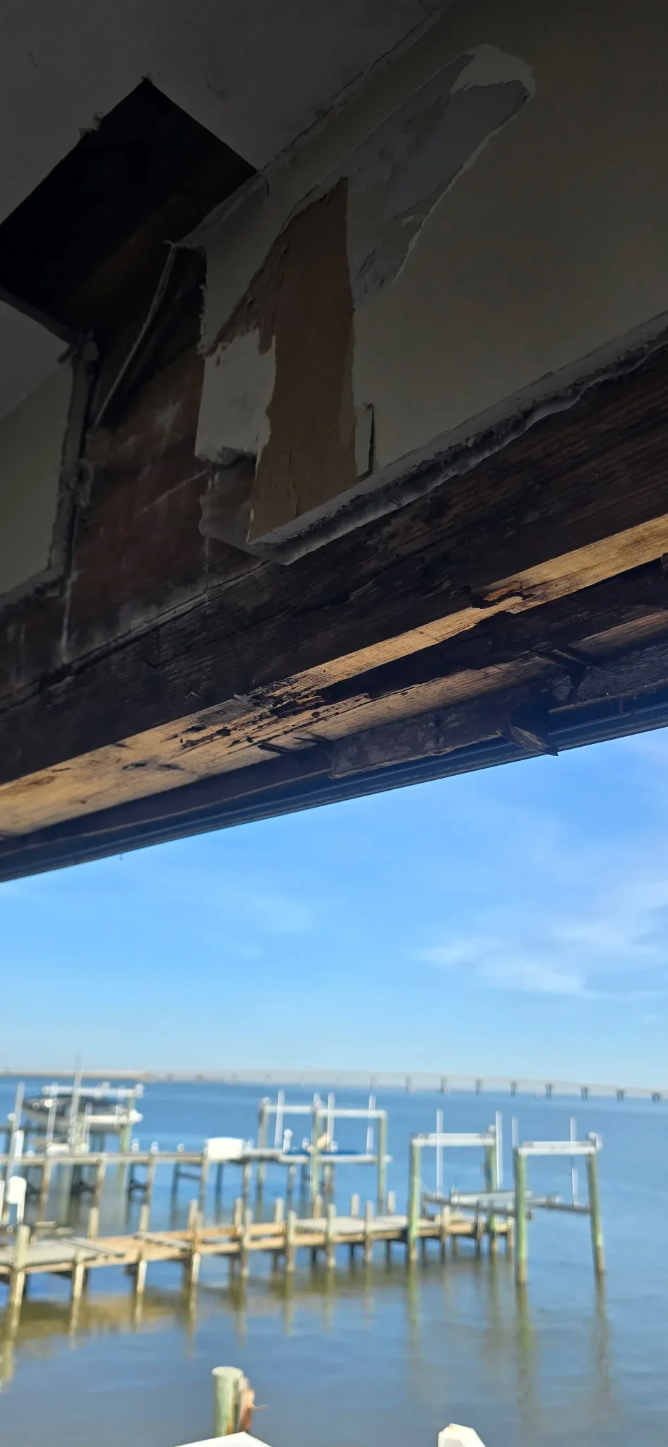 Restored wood beam and drywall soffit on waterfront structure with water view