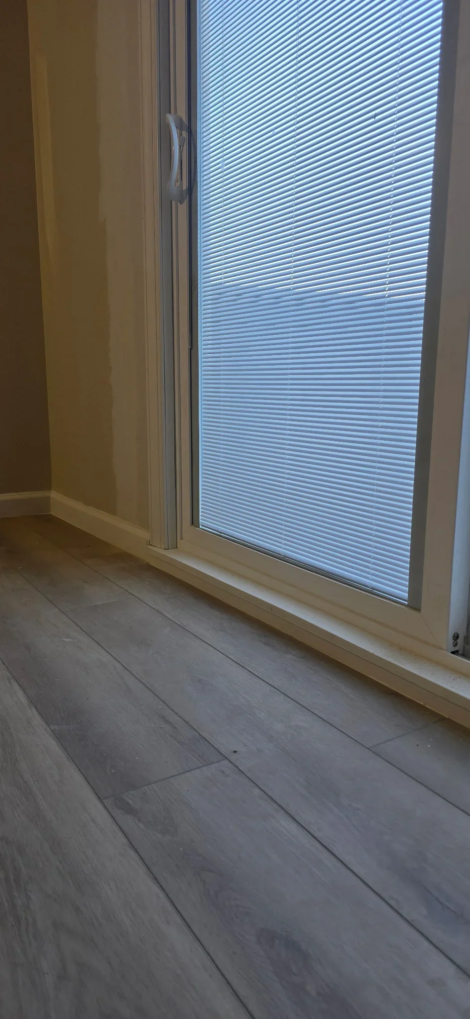 Sliding glass door with built-in blinds and laminate flooring installation