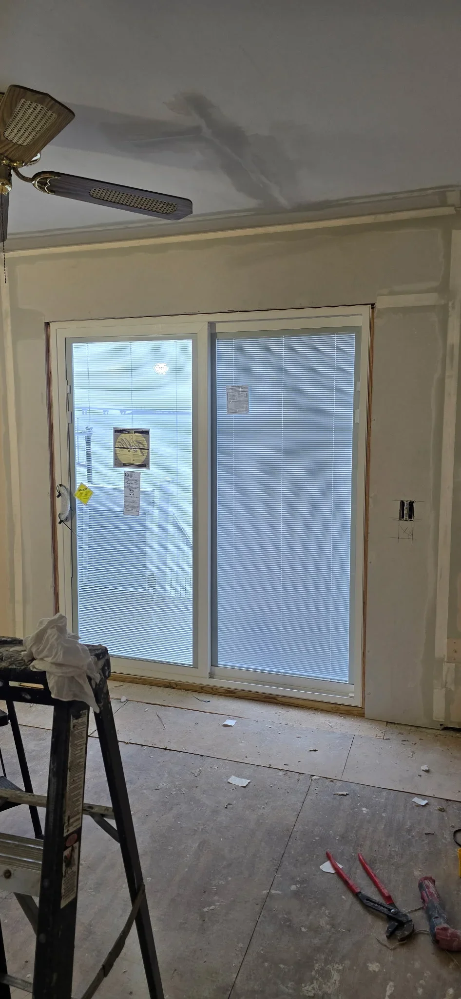 Aluminum sliding glass doors with integrated blinds installed in kitchen opening