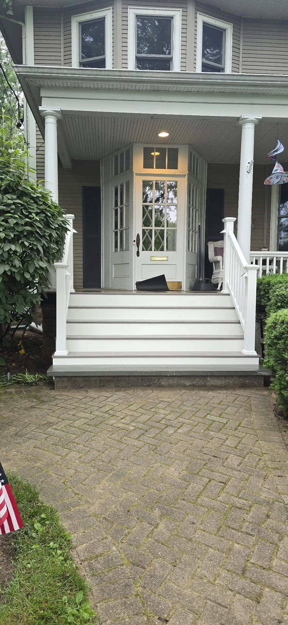 White composite deck porch with columns, railings, and coffered ceiling