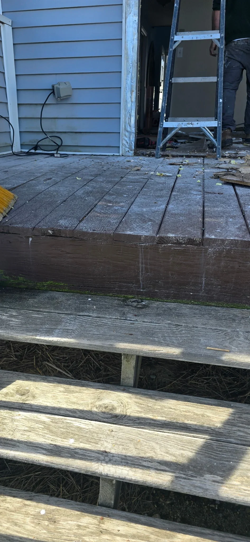 Multi-level wooden deck with new composite decking and pressure-treated lumber framing during construction
