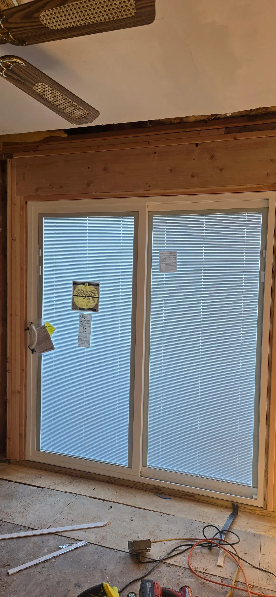 Two sliding glass doors with integrated blinds in wood frame during installation