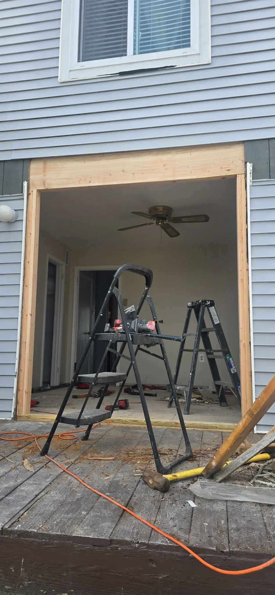 Sunroom addition with wood framing, drywall, and ceiling fan installation