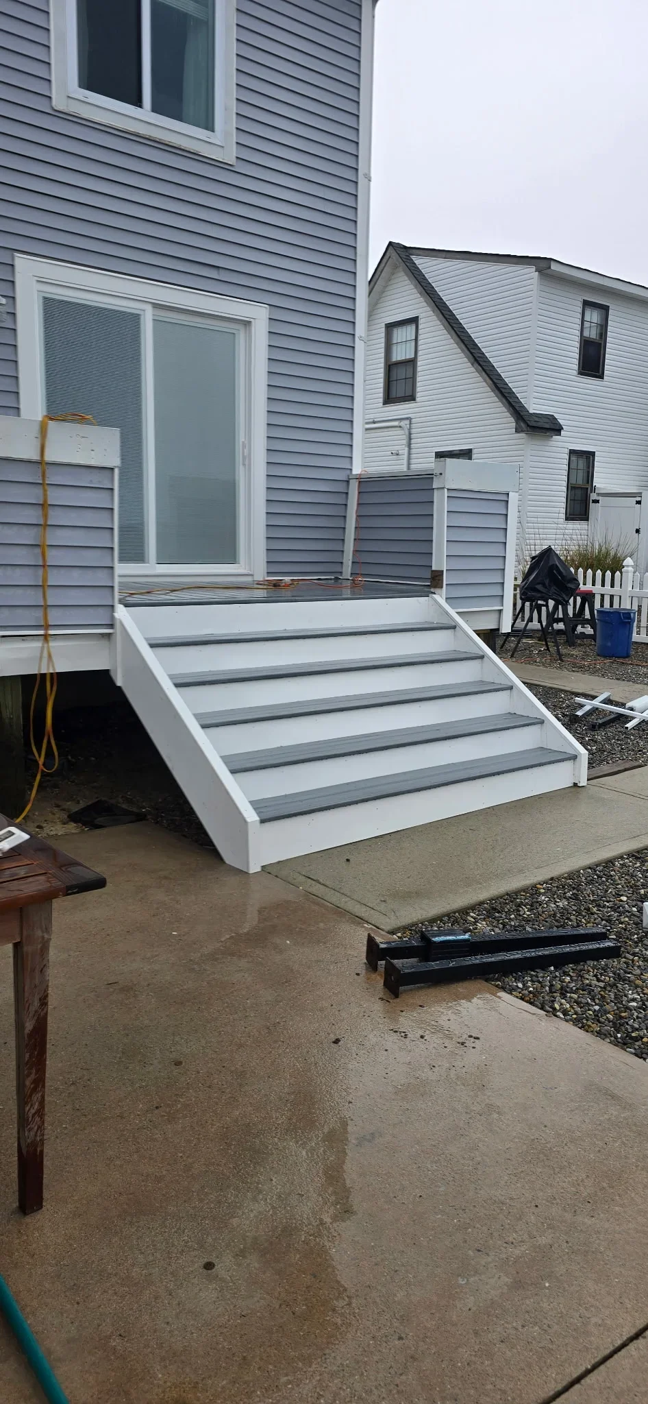 Composite deck stairs with gray and white treads, white fascia, and railing
