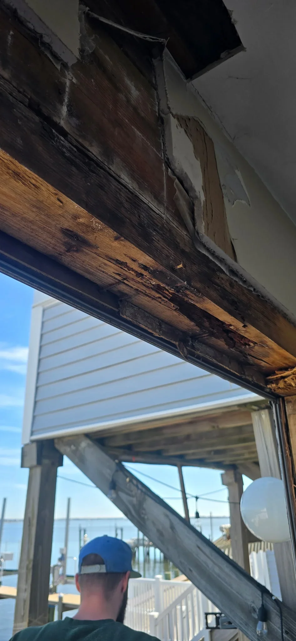 Charred wooden beam and fire-damaged soffit being replaced with new treated lumber framing